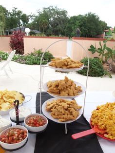 a table topped with plates filled with different types of food next to bowls of dips