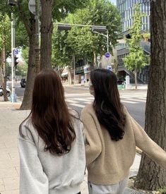 two women are walking down the street together