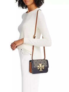 The small Eleanor shoulder bag from Tory Burch flaunts a T monogram jacquard upper with leather trim. Signature Double T hardware and contrast stitching finish this piece..Adjustable, removable shoulder strap.Interior: one front slip, one back zip pocket.Clasp closure.Textile.Trim: leather.Lining: 100% polyurethane.Imported.SIZE.About 7.5'W x 5.25'H x 2.5'D.ABOUT THE BRAND.Since debuting her brand in 2004, New York-based designer Tory Burch has made an impact on the fashion world with her handbags and shoes, and playful-yet-polished clothing. Today, Burch remains inspired by color and travel, with her vibrant collections bursting with prints, and her instantly recognizable double-T logo drawing from Moroccan architecture..The small Eleanor shoulder bag from Tory Burch flaunts a T monogram Tan Monogram Canvas Satchel Shoulder Bag, Tan Monogram Canvas Shoulder Bag With Detachable Strap, Luxury Tan Crossbody Shoulder Bag, Luxury Monogram Canvas Tan Shoulder Bag, Luxury Tan Monogram Canvas Shoulder Bag, Tan Monogram Canvas Shoulder Bag With Leather Trim, Tan Bags With Leather Trim And Monogram Canvas, Tan Monogram Canvas Bag With Leather Trim, Luxury Tan Bag With Leather Trim