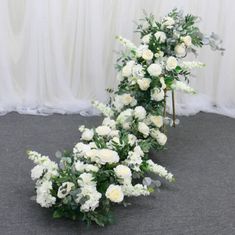 a bunch of white flowers sitting on top of a carpeted floor next to a curtain