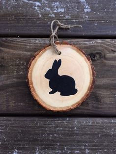 a wooden slice with a black rabbit on it