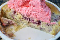 a piece of cake with pink ice cream on top in a white bowl next to a fork