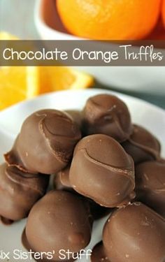 chocolate orange truffles on a white plate with an orange in the background