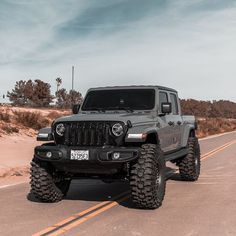 the jeep is driving down the road with its wheels on it's rims