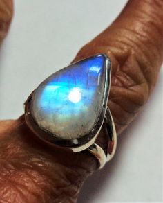 Vintage rainbow moonstone ring with bright aqua blue to deep cobalt blue flash in a solid sterling silver ringThe spectacular colors in this gem range from pale aqua to peacock blue to deep cobalt blue throughout the gorgeous pear moonstone.The pearl rainbow moonstone ring is a size 7.  The ring is well crafted of solid sterling silver, and has an open back so the lovely moonstone energy can be felt on your finger.This vintage ring was stored carefully, and has been cleaned and polished.  It is Fusion Style Oval Moonstone Ring Gift, Oval Moonstone Fusion Ring Gift, Teardrop Moonstone Gemstone Ring, Fusion Style Moonstone Gemstone Jewelry, Large Moonstone Spiritual Ring, Mystical Cabochon Jewelry For Anniversary, Fusion Style Moonstone Jewelry For Anniversary, Unique Moonstone Ring With Large Stone, Unique Large Moonstone Ring