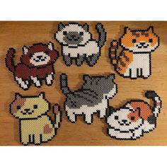 cross stitch cats and kittens on a wooden surface