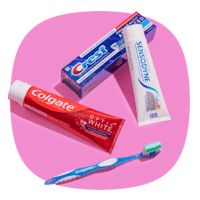 toothpaste and toothbrush on pink background