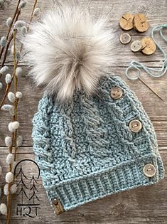 a knitted hat with buttons and a fur pom