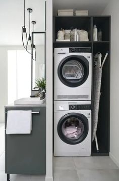 a washer and dryer in a room with white tile flooring on the walls