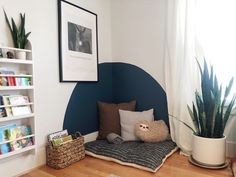 a room with bookshelves, plants and stuffed animals