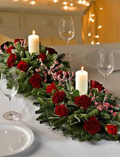 the table is set with candles, flowers and greenery for a festive centerpiece