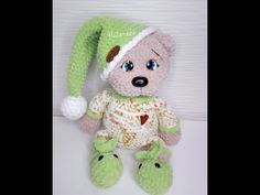 a teddy bear wearing a green hat and turtle slippers sitting on a white surface