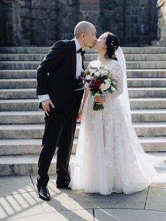 a bride and groom kissing in front of some steps