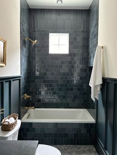 a bath room with a toilet a tub and a mirror on the wall in it