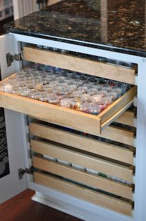 an open drawer in a kitchen filled with glasses