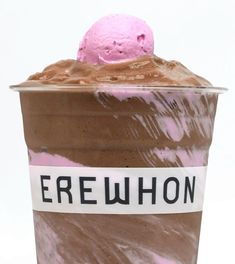 an ice cream sundae with chocolate and pink frosting in a plastic cup on a white background