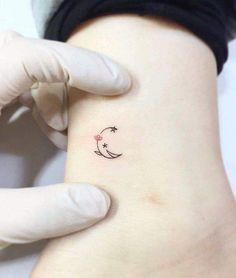 a person with a small tattoo on their left arm and the moon behind them is shown