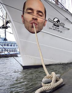 a man is chewing on a rope in front of a large ship with the caption advertising win