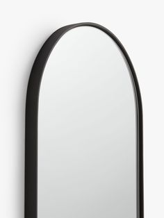 an arched mirror is shown against a white wall with black trimmings on the edges