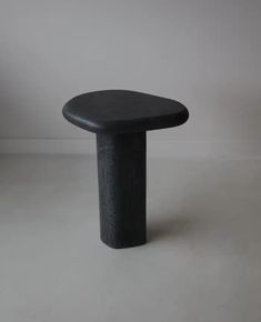 a black stool sitting on top of a white floor