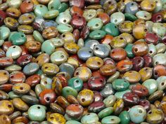 many different colors and sizes of beads are shown in this close up photo, with one bead facing the camera