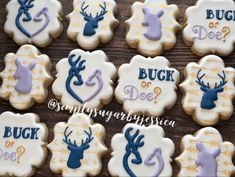 some decorated cookies are sitting on a wooden table with the words buck or doe written on them