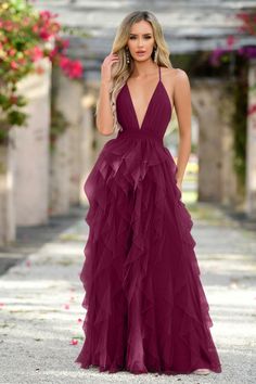 A woman wears a deep burgundy, floor-length dress with layered ruffles, standing confidently in a floral courtyard with soft lighting and greenery in the background, suggesting a romantic setting. Bachelorette Party Dress, Rehearsal Dinner Dresses, Elegant Maxi Dress, Rehearsal Dress, Maxi Dress Wedding, Floor Length Gown, Dinner Dress, Multicolor Dress, Tulle Fabric