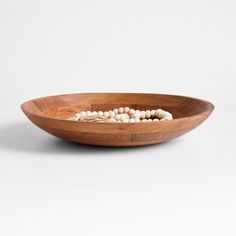 a wooden bowl with white beads in it