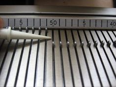 a person is using a ruler to measure pins