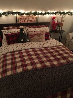 a christmas themed bedroom with plaid bedding and lights on the headboard, along with decorations