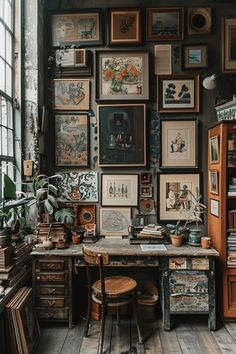 a room with lots of framed pictures on the wall and wooden furniture in front of it