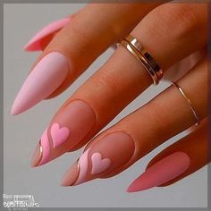 a woman's hand with pink and gold nail polishes on her nails, holding a ring