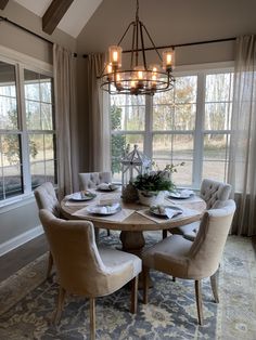 a dining room table with chairs and a chandelier hanging from it's ceiling