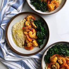 three plates with shrimp, spinach and grits on them next to a blue and white towel