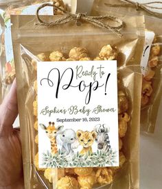 someone is holding up a bag of baby shower popcorn with animals on it and the label reads ready to pop