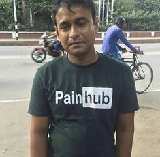 a man standing in the street wearing a shirt that says painhub