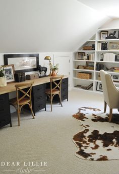 an attic office with cow hide rug, desk and bookcases in the corner