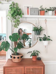 a woman taking a selfie in front of a mirror with plants on the wall