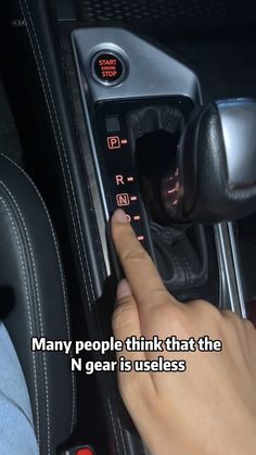 a person is pressing the button on a car's gear selector that says, many people think that the n gear is useful