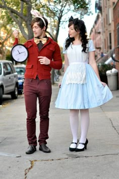 a man and woman dressed up as alice and the mad hatter on a city street