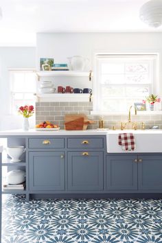 a kitchen with blue cabinets and white counter tops