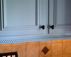 the cabinets in this kitchen are painted white and have black knobs on each side