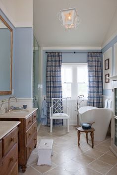 a bath room with a tub a sink and a mirror