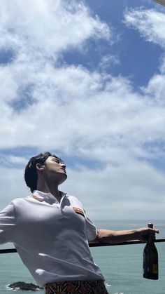 a man standing next to the ocean looking up