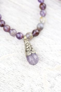 We are so excited to introduce our DharmaShop exclusive Super Seven Mala! Hand strung here in Detroit with genuine Super Seven beads from Brazil and a faceted Amethyst gemstone pendant from Nepal. Super Seven is a rare mineral made from a blend of seven crystals including: Amethyst, Clear Quartz, Smoky Quartz, Cacoxenite, Rutile, Geothite, and Lepidocrocite. This incredibly powerful stone combines the healing properties of all seven crystals! Super Seven is believed to energize and heal all seve Spiritual Fluorite Gemstone Beads Jewelry, Spiritual Amethyst Necklace With Faceted Beads, Spiritual Faceted Amethyst Crystal Necklace, Spiritual Lavender Jewelry With Faceted Beads, Lavender Spiritual Jewelry With Faceted Beads, Faceted Spiritual Gemstones For Healing, Lavender Crystal Necklaces With Faceted Beads For Gifts, Spiritual Healing Faceted Gemstones, Lavender Faceted Beads Crystal Necklace Gift