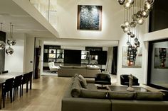 a living room filled with furniture next to a dining room table and chairs on top of a hard wood floor