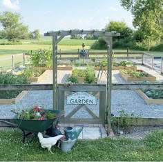 an outdoor garden area with raised beds and flowers in the center, surrounded by chickens