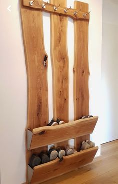 a wooden bench with shoes on it in front of a wall mounted coat rack and mirror