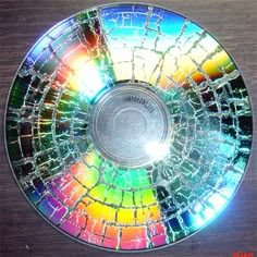 a broken glass disk sitting on top of a wooden table