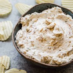 a bowl filled with dip surrounded by chips